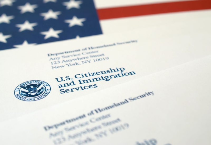Envelopes With Letter From Uscis On United States Flag From Department Of Homeland Security Envelopes with letter from USCIS on United States flag from Department of Homeland Security close up